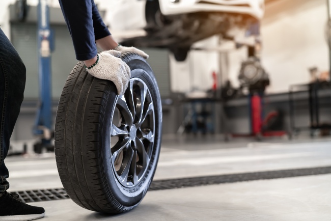 A Mechanic Changes a Wheel Tire and Performs Service Maintenance at Rim Doctor in Baltimore, MD.